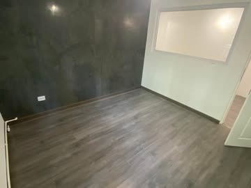 After - Bedroom with decorative dark feature wall and laminate flooring