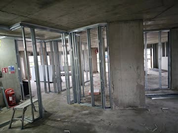 Drylining to concrete soffit - partition framing in corridor