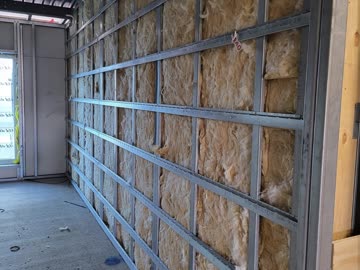 Insulation packed between studs along a full elevation